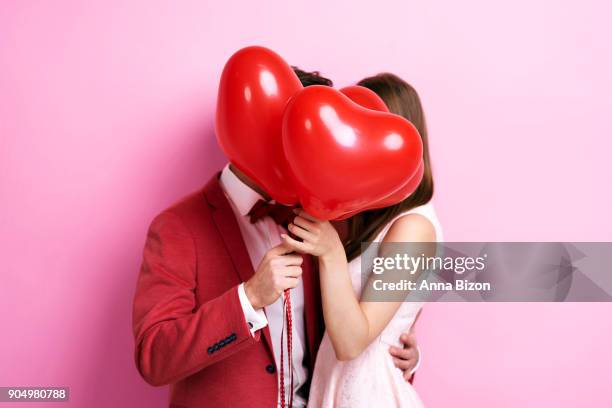 couple kissing behind balloons. debica, poland - romance cover stock pictures, royalty-free photos & images