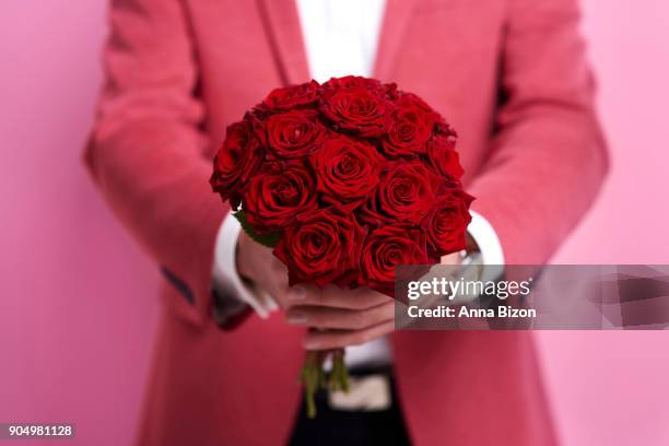 unrecognizable man giving bunch of rose. debica, poland - man holding out flowers stock pictures, royalty-free photos & images