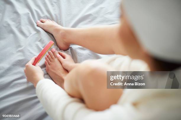 high angle view of woman filling nails. debica, poland - nail file stock pictures, royalty-free photos & images