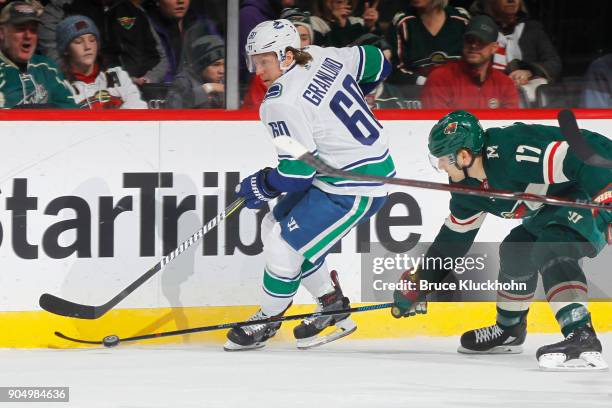 Markus Granlund of the Vancouver Canucks skates with the puck against Marcus Foligno of the Minnesota Wild during the game at the Xcel Energy Center...