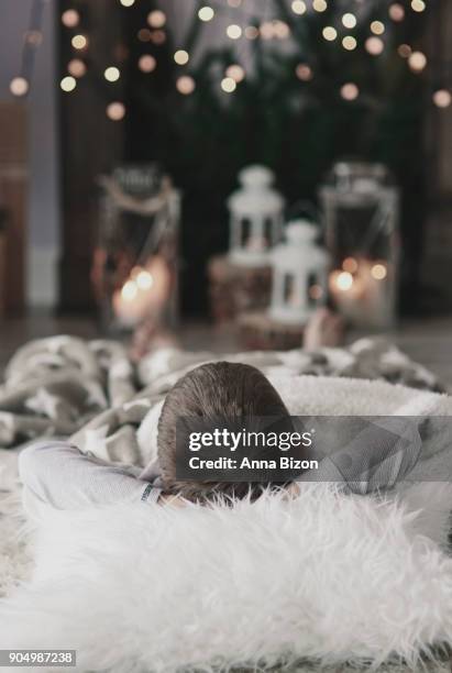 boy with hands behind head lying on floor. debica, poland - stretching hands behind head rear view stock-fotos und bilder