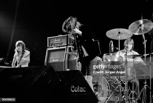 Malcolm Young, Angus Young, Phil Rudd from AC/DC perform live on stage in Copenhagen, Denmark in April 1977