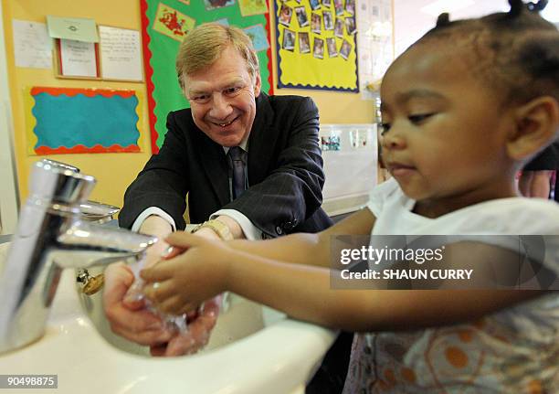 British Chief Medical Officer Sir Liam Donaldson washes his hands with a child during a visit to Tyssen Community School, in north London, to help...