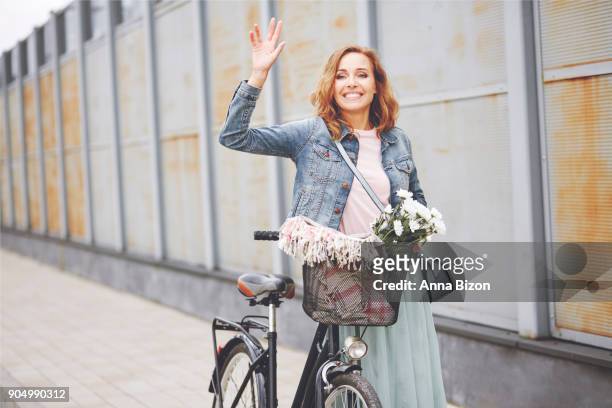 beauty woman with bike waving for someone. debica, poland - anna of poland fotografías e imágenes de stock