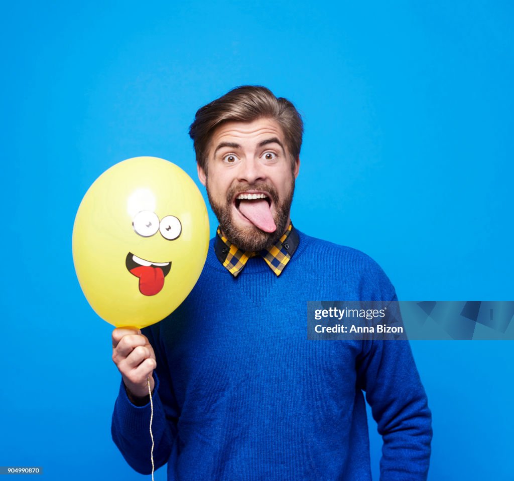 Man with balloon sticking his tongue out. Debica, Poland
