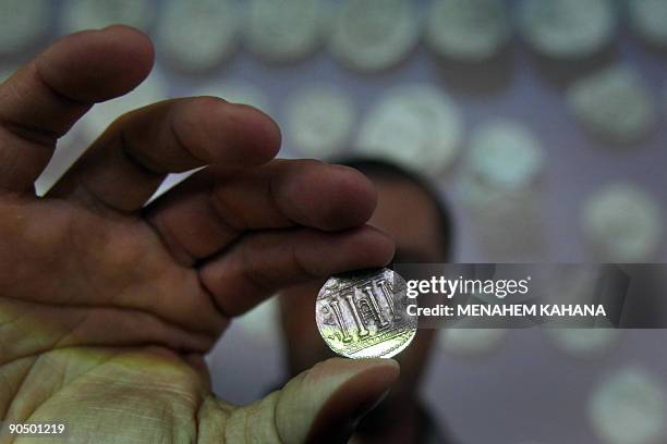 Archaeologist Boaz Zisso shows one of the recently found 120 coins related to the so-called Bar Kokhba revolt during a press conference at the...