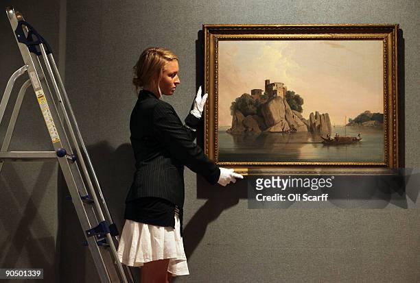 Bonhams gallery assistant adjusts a painting by Thomas Daniell entitled 'Carved Rocks at Sultaungunge, Bihar' which is expected to fetch up to 90,000...