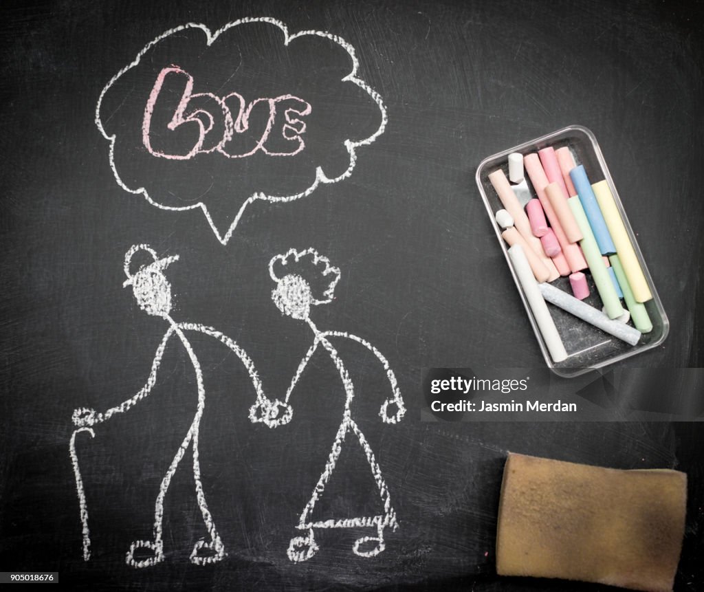 Senior couple love illustrated with chalk on blackboard