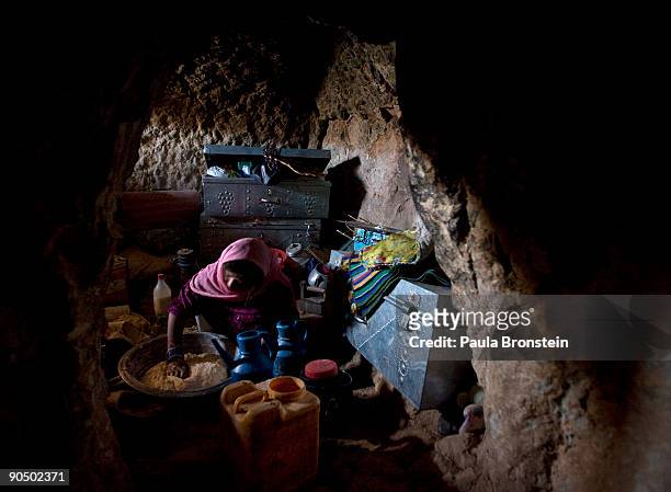 Sukinah mixes the flour for making bread inside the family cave dwelling September 5, 2009 in Bamiyan, Afghanistan. Many of the impoverished families...