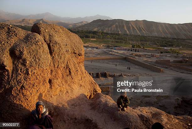 Afghan children sit outside their cave dwelling September 6, 2009 in Bamiyan, Afghanistan. Many of the impoverished families living in the caves say...