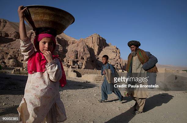 Girl carries some washed clothing as Afghans living in the caves head home September 2, 2009 in Bamiyan, Afghanistan. Many of the impoverished...
