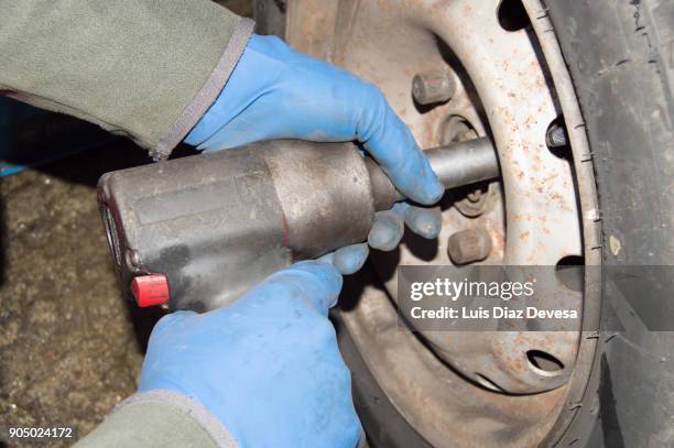 mechanic working on car tire - tyre side view foto e immagini stock