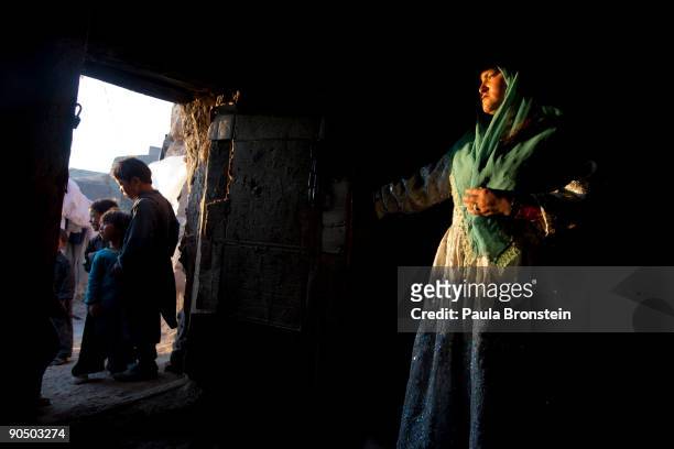 Khadija looks after the younger children as she peers out from their cave dwelling September 7, 2009 in Bamiyan, Afghanistan. Many of the...