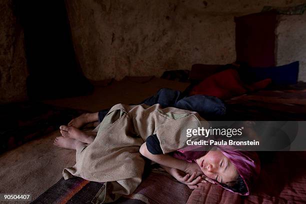 Fauzia naps in the afternoon next to her brother Mohammed inside their cave dwelling on September 6, 2009 in Bamiyan, Afghanistan. Many of the...