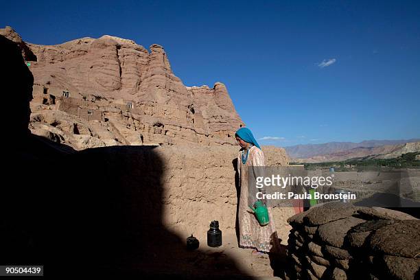 Sima carries water to her cave dwelling on September 2, 2009 in Bamiyan, Afghanistan. Many of the impoverished families living in the caves say they...