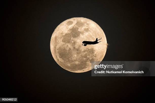 aircraft fly pass supermoon at night - supermoon stock pictures, royalty-free photos & images