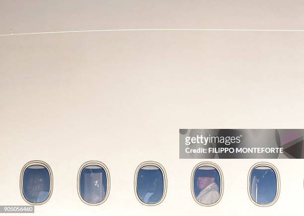 Pope Francis's looks out from the window of a plane at Rome's Fiumicino Airport on January 15, 2018 for his trip to Chile. - Pope Francis set off on...