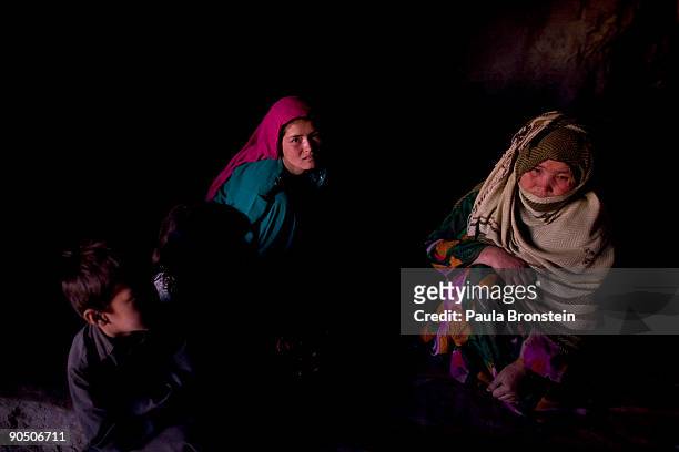 Hakima sits with her mother Rokia and children in the family cave September 6, 2009 in Bamiyan, Afghanistan. Many of the impoverished families living...