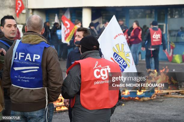 Prison guards wear union vests as they block access to the prison of Gradignan on January 15, 2018. The first operations of "total blockage" of...