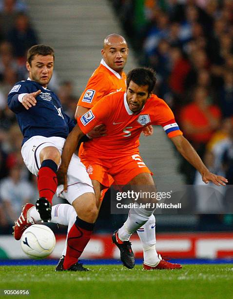 Shaun Maloney of Scotland tackles Giovanni van Bronckhorst of Netherlands during the FIFA 2010 World Cup Group 9 Qualifier match beteween Scotland...