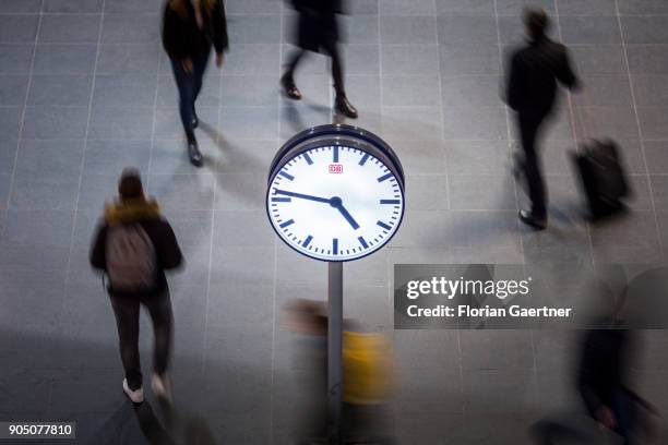Clock is pictured in front of walking travellers on January 11, 2018 in Berlin, Germany.