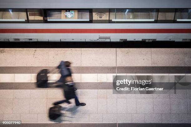 Two traveller with trolley bags walks along a train on January 11, 2018 in Berlin, Germany.