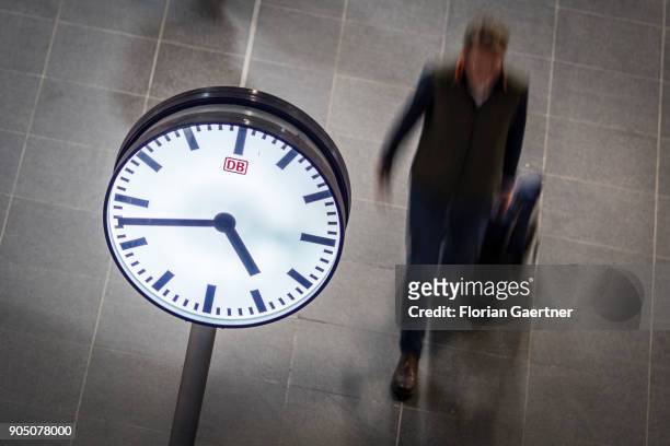 Clock is pictured in front of a walking traveller on January 11, 2018 in Berlin, Germany.