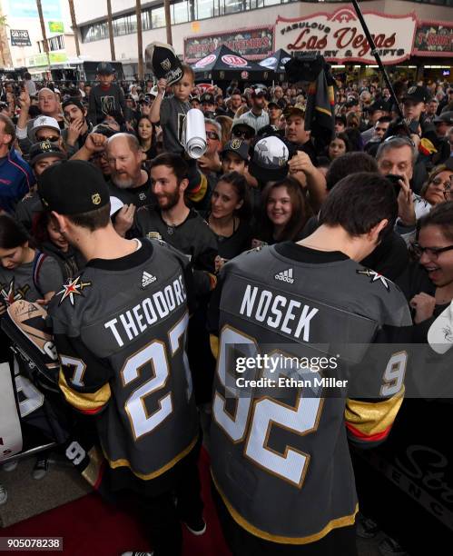 Shea Theodore and Tomas Nosek of the Vegas Golden Knights sign autographs for fans as they walks a red carpet at the Vegas Golden Knights Fan Fest at...