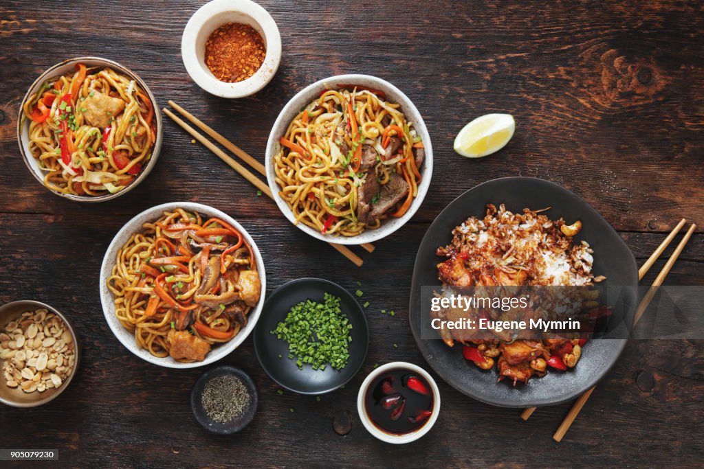 Bowls with chicken, beef and vegetables chow mein and rice with pork