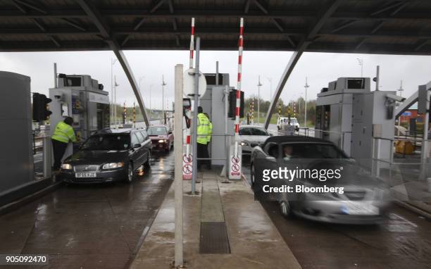 Automobiles are seen as they exit the Great Wyrley payment booths, part of the M6 motorway toll road near Cannock, U.K., on Friday, April 27, 2012....