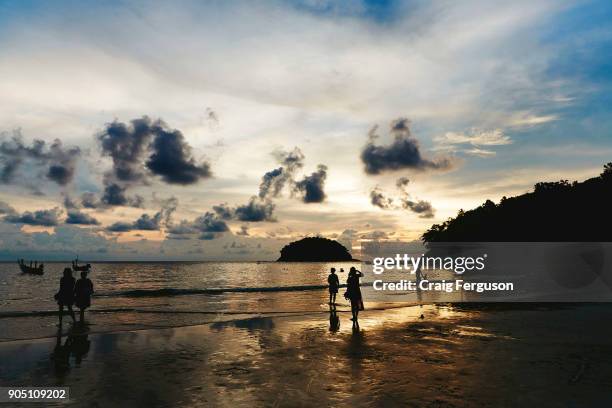 Tourists play on the beach and enjoy the sunset on one of Phuket's beaches. The island attracts more than 5 million tourists each year who flock...