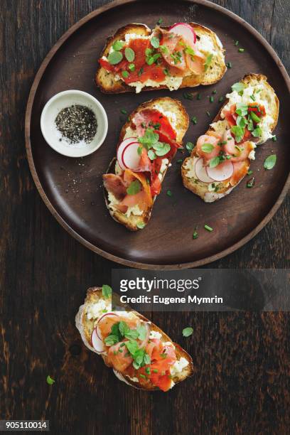 bruschetta with smoked trout and mascarpone scrambled eggs - trout stock photos et images de collection