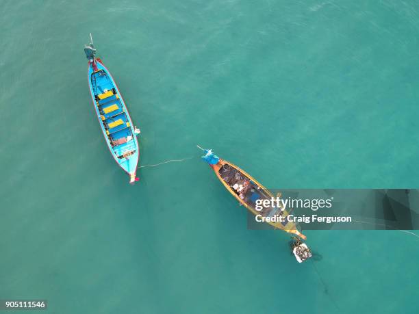 Aerial view of two longtail boats in the Andaman Sea. The small watercraft are commonly seen all over Thailand, particularly the seaside locations in...