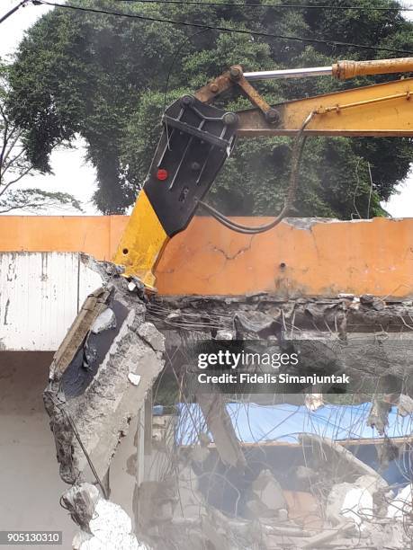 hydraulic breaker/hammer (excavator) destroying a building - indonesia electricity development in jakarta stock pictures, royalty-free photos & images