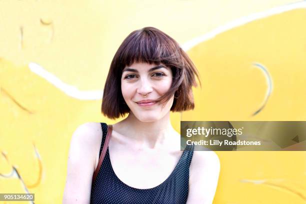 Portrait of young woman against city street art