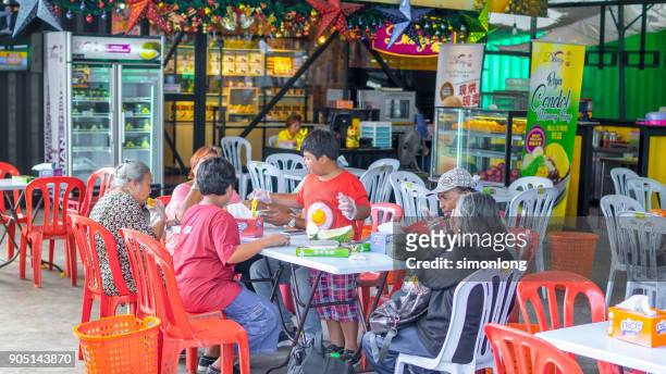 a family is sitting down & enjoying durian at ss2, malaysia - famous food programa de televisión fotografías e imágenes de stock