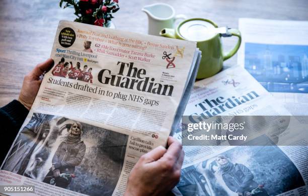 In this photo illustration a woman reads the new tabloid size The Guardian newspaper that was launched today with a new masthead on January 15, 2018...