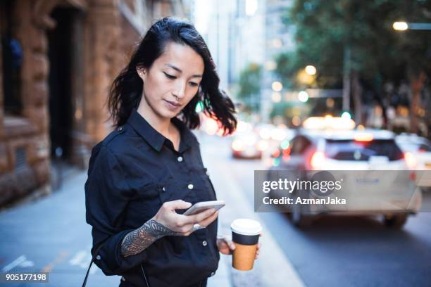 businesswoman using smart phone and waiting for a taxi - australia taxi stock pictures, royalty-free photos & images