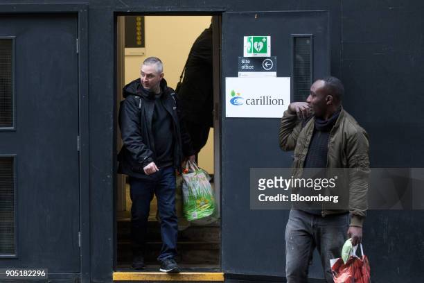 Workers carry plastic bags from the site office of the Arundel Great Court development, operated by Carillion Plc, in London, U.K., on Monday, Jan....