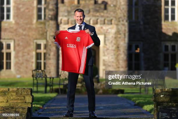 Ryan Giggs poses with a Welsh shirt after attending a press conference as he is announced as the new manager of Wales at Hensol Castle on January 15,...