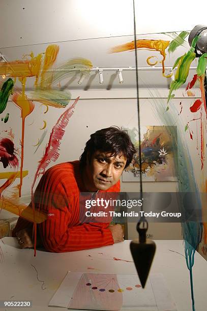 Painter Niladri Paul displays the process of colour therapy using a pendulum in New Delhi, India