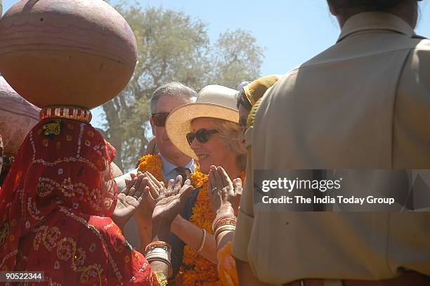 Prince Charles and wife Camilla Parker discussing with the ladies assembled for collecting water with their earthen pots near a water tank in their...