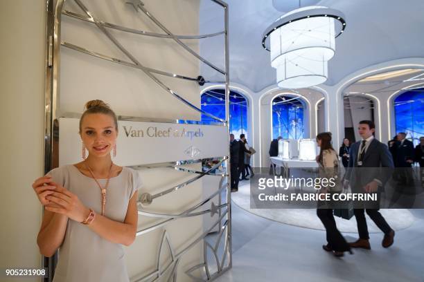 Hostess poses at the stand of the French jewelry, watch, and perfume company Van Cleef & Arpels, owned by Switzerland-based luxury goods holding...