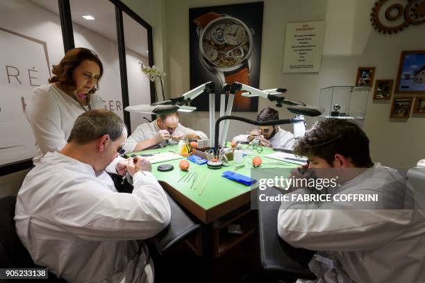 Watchmakers train at a stand on the opening day of the 28th International Fine Watchmaking Exhibition SIHH, on January 15, 2018 in Geneva. / AFP...