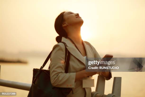 businesswoman standing with head back and eyes closed - wap stock pictures, royalty-free photos & images