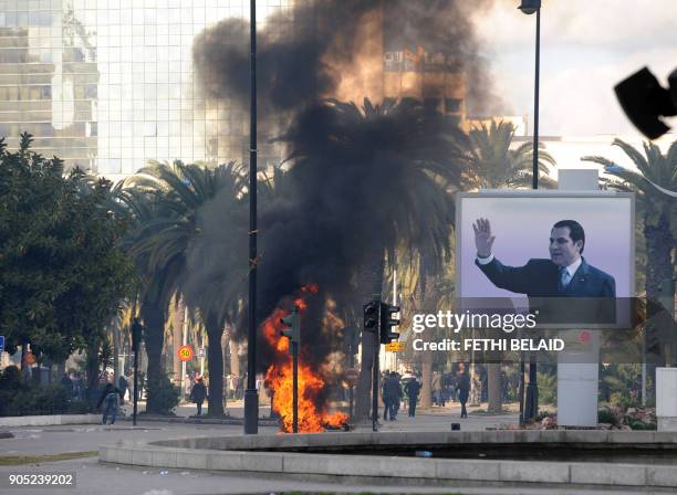 Smoke rises from fire left after clashes between security forces and demonstrators in Tunis on January 14, 2011 after Tunisian President Zine El...