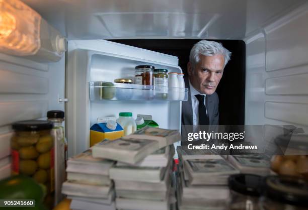 pov man putting looking at stacks of us dollars in the fridge - hiding money stock pictures, royalty-free photos & images