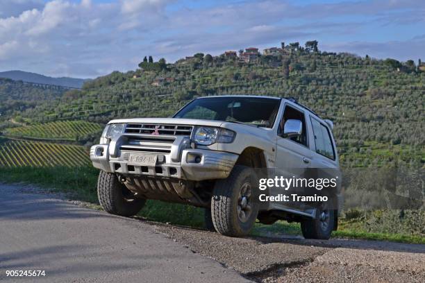 mitsubishi pajero drijven op de weg - mitsubishi group stockfoto's en -beelden