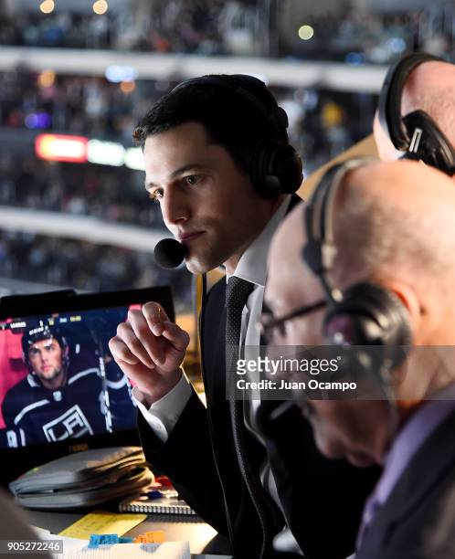 Los Angeles Kings play-by-play announcer Alex Faust calls the game as former Kings announcer Bob Miller visits the broadcasting booth during the game...