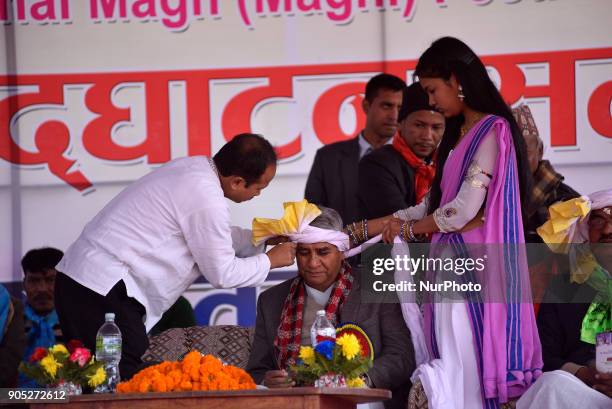 Nepalese Tharu community youth tighten traditional head turban on Prime Minister Sher Bhadur Deuba during Maghi festival celebrations or the New Year...